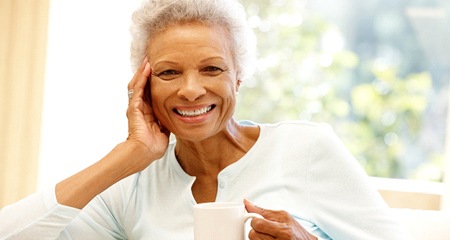 An older woman with a denture smiling