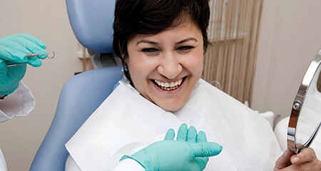 Smiling woman in dental chair for dental checkup and teeth cleaning