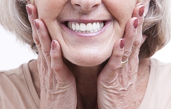 Closeup of smiling woman with implant dentures in Gainesville