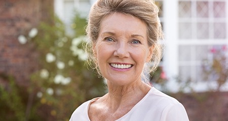 Older woman with dentures in Gainesville smiling outside