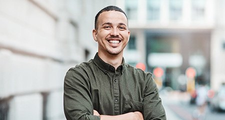 a smiling man with his arms crossed