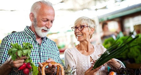 elderly couple shopping for fresh fruits and vegetables
