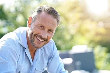 man smiling as a good candidate for implant dentures in Gainesville