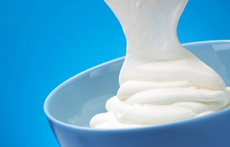 Close up of white yogurt with blue background