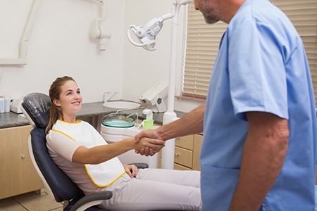 Patient shaking dentist’s hand after dental implant salvage in Gainesville, FL