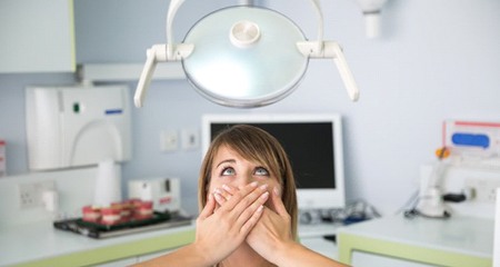 Woman in need of I V sedation dentistry afraid in dental chair