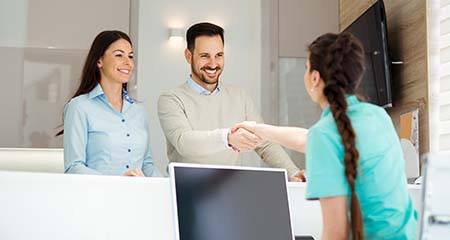 Patients being greeted by front desk clerk