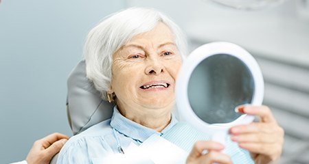 Woman admiring her new smile with TeethXpress in Gainesville