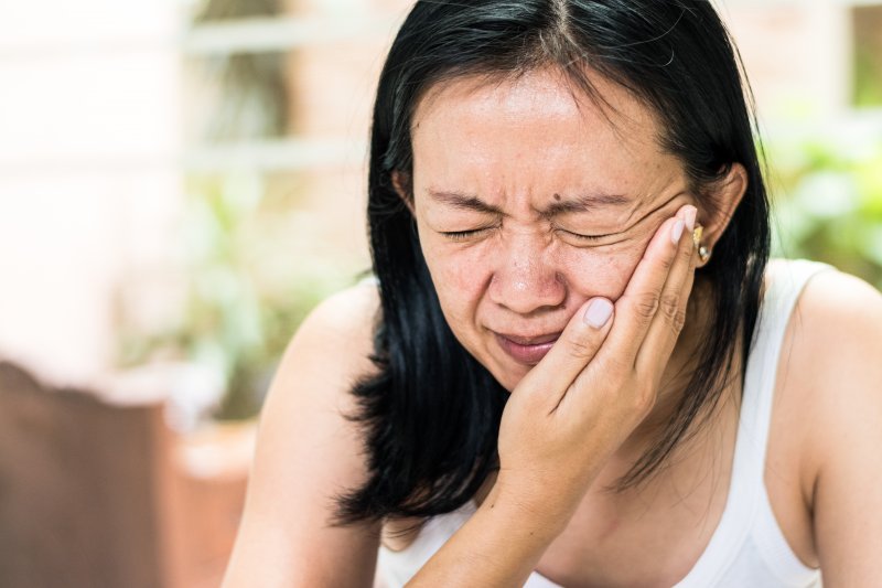 Woman with toothache needing to see emergency dentist