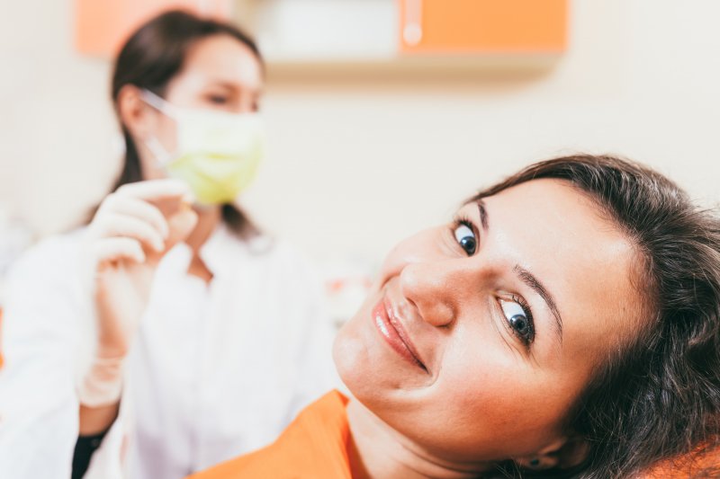 A smiling woman who just received a tooth extraction