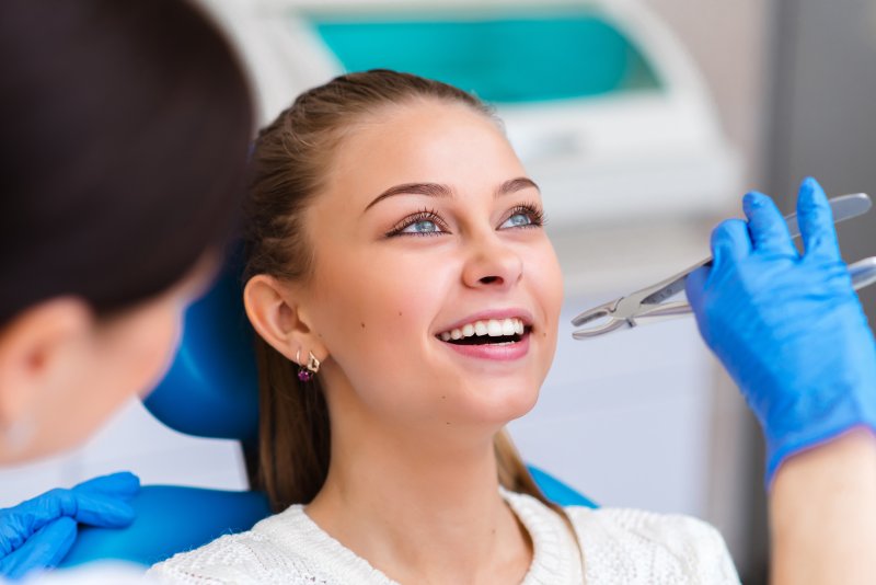 A smiling woman about to receive a tooth extraction