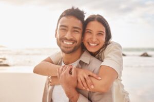 smiling couple hugging on the beach